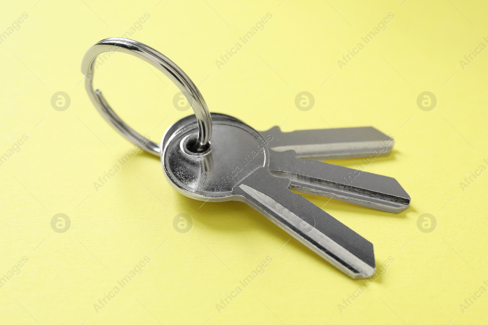 Photo of Keys with ring on yellow background, closeup