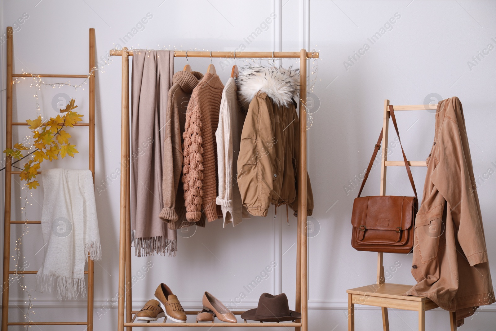 Photo of Rack with stylish warm clothes, shoes and accessories in modern dressing room