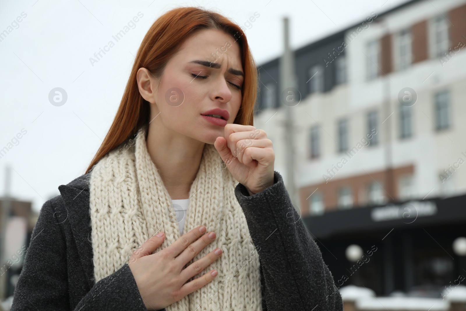 Photo of Beautiful young woman coughing outdoors, space for text. Cold symptoms