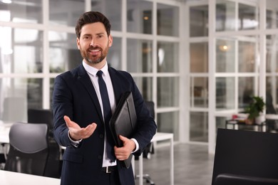 Happy real estate agent with leather portfolio in office