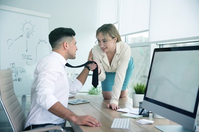 Image of Colleagues flirting with each other during work in office. Cheating concept