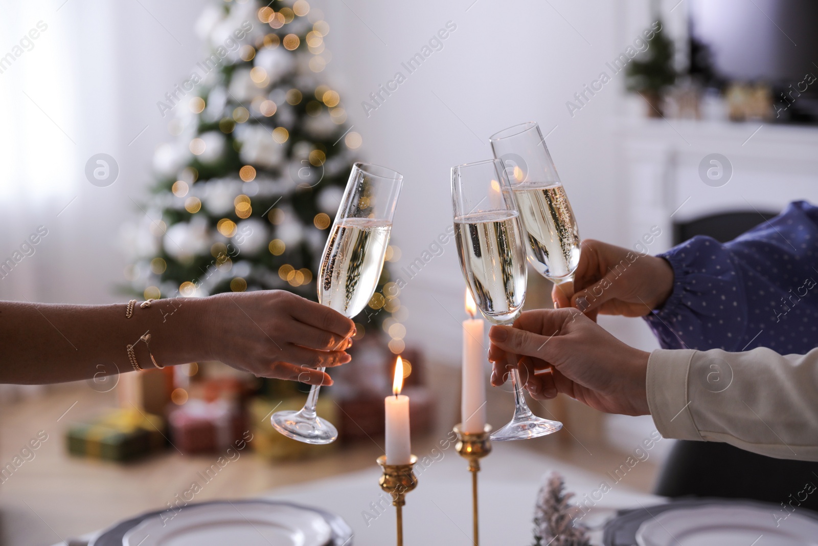 Photo of People clinking glasses with champagne at home, closeup