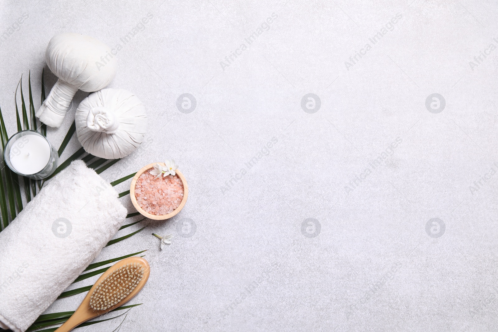 Photo of Flat lay composition with herbal massage bags and spa products on light grey table. Space for text