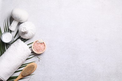 Photo of Flat lay composition with herbal massage bags and spa products on light grey table. Space for text