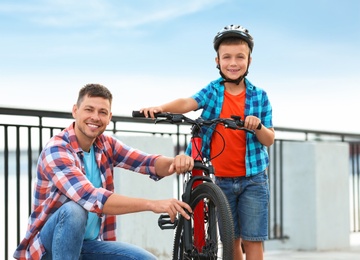 Dad and son with bicycle near river