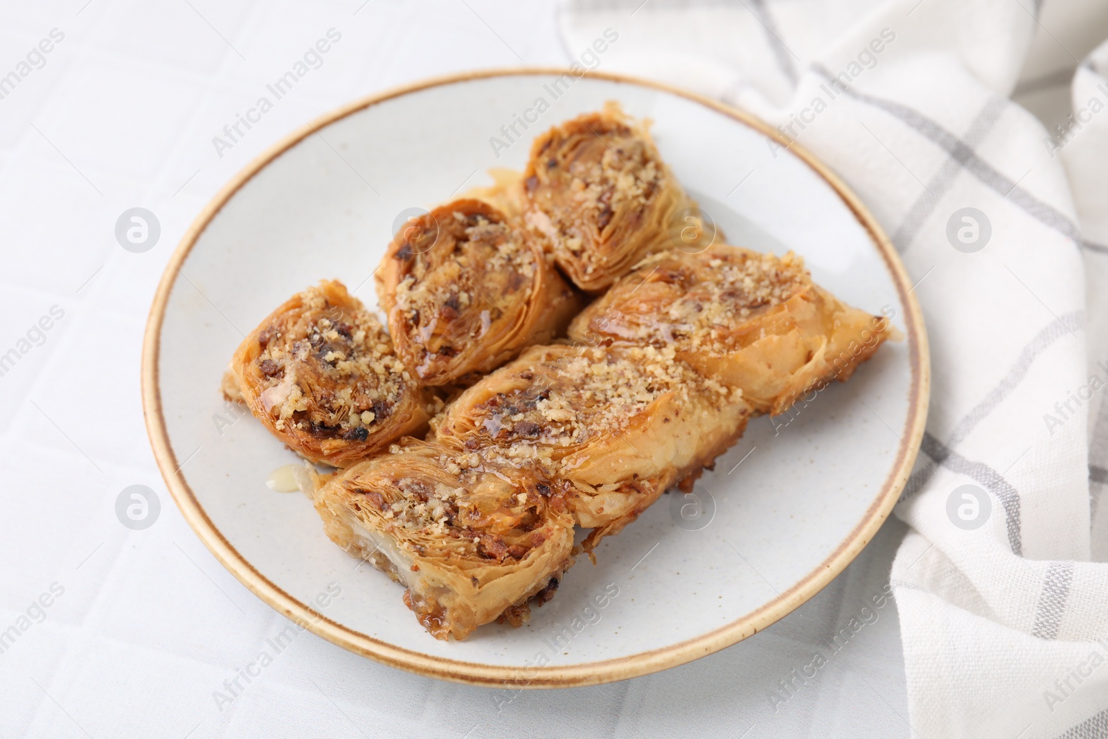 Photo of Eastern sweets. Pieces of tasty baklava on white tiled table