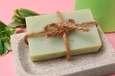 Dish with soap bar on pink background, closeup