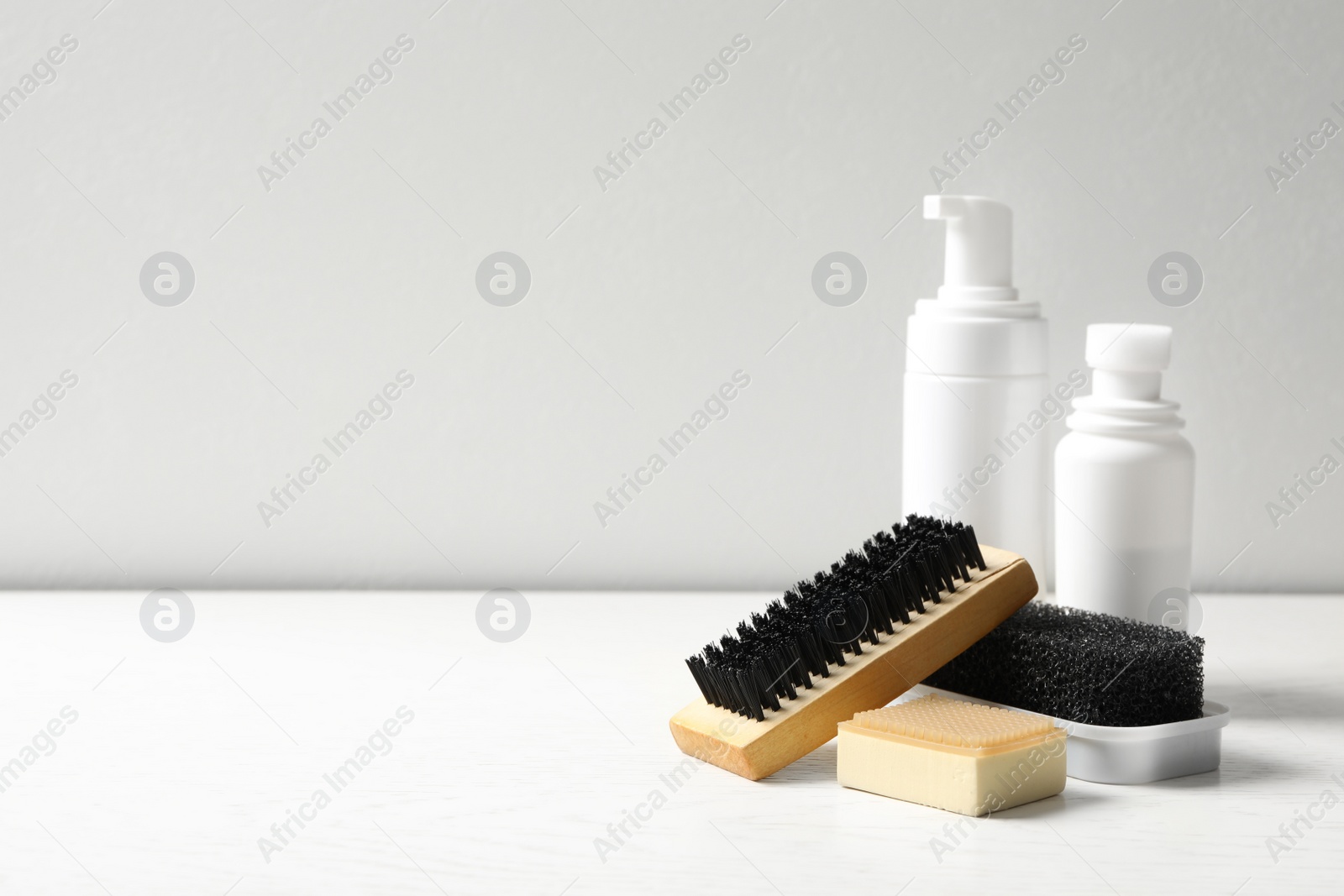 Photo of Composition with shoe care accessories on white table, space for text