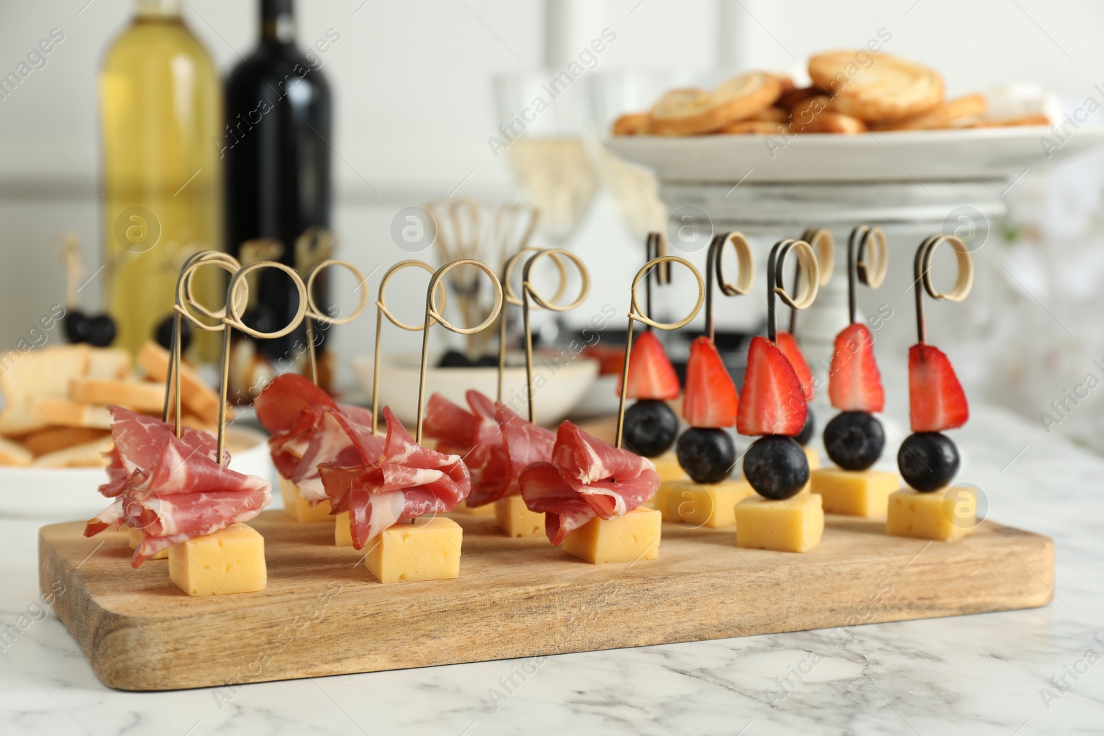 Photo of Different tasty canapes on white marble table, closeup