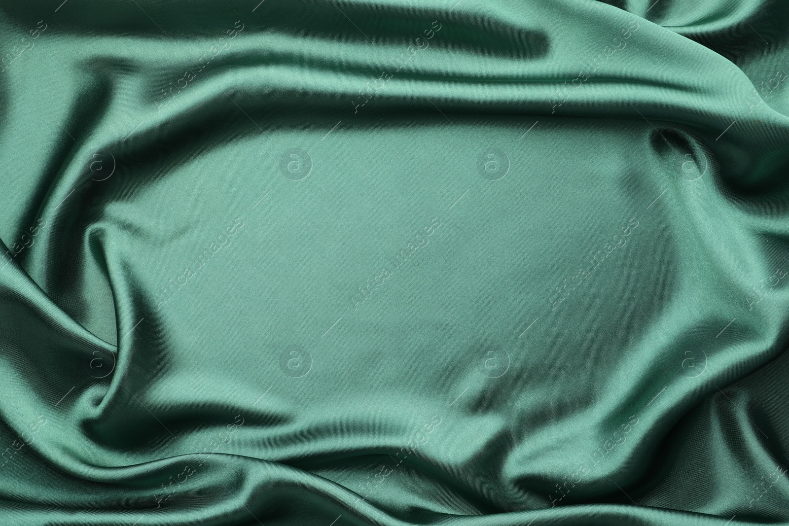 Photo of Crumpled green silk fabric as background, top view