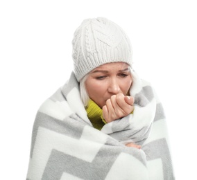 Mature woman wrapped in warm blanket suffering from cold on white background