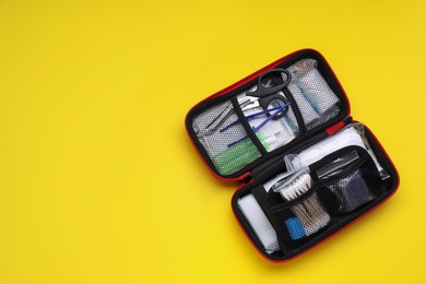 Photo of First aid kit on yellow background, top view and space for text