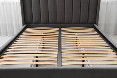 Photo of Modern bed with storage space for bedding under slatted base in room, closeup