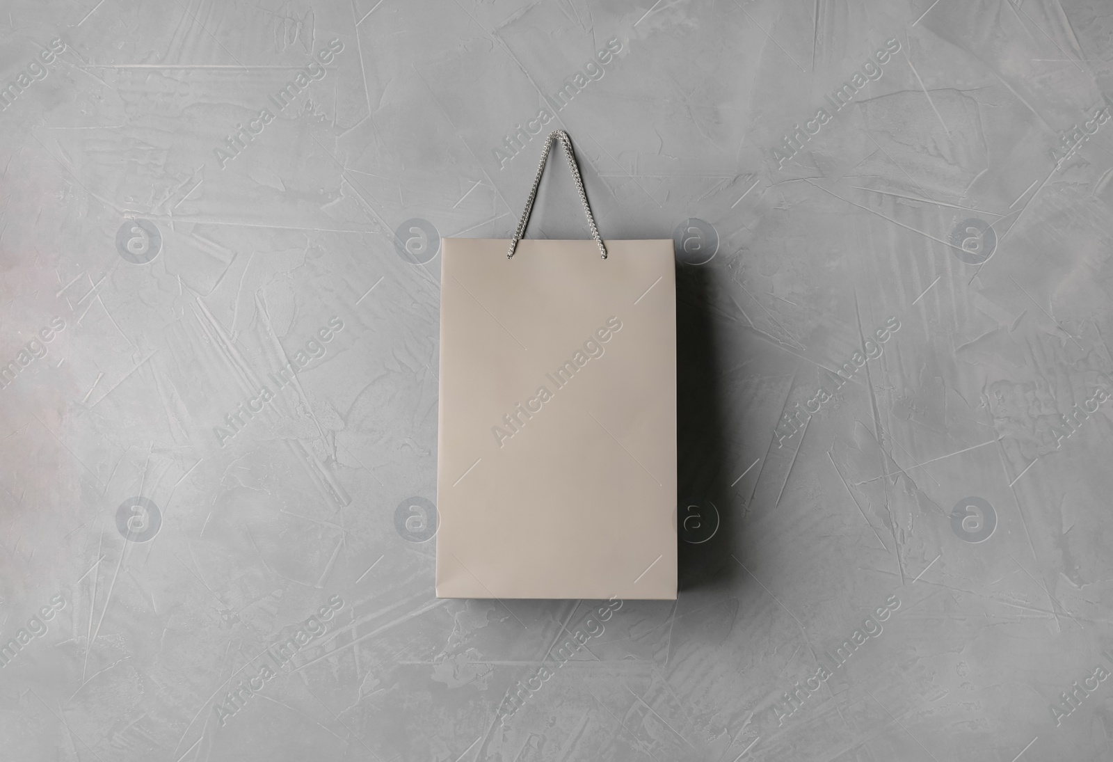 Photo of Paper shopping bag hanging on grey wall