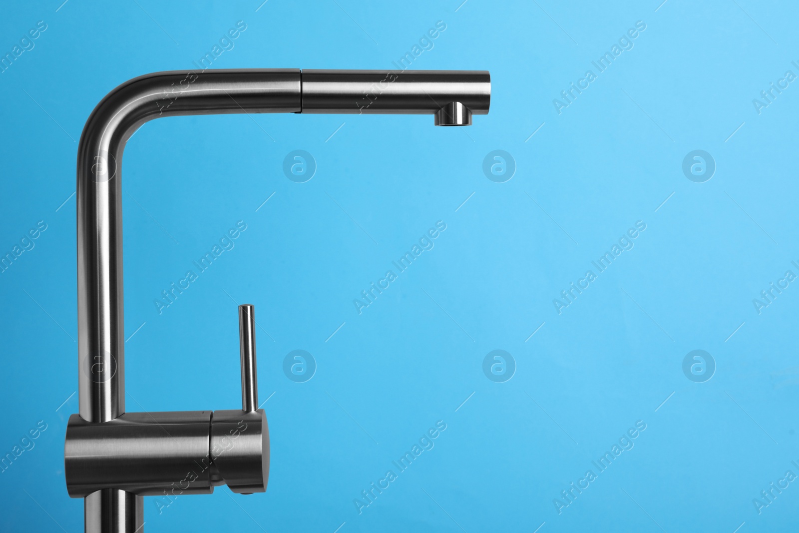 Photo of Modern pull out kitchen faucet on light blue background. Space for text