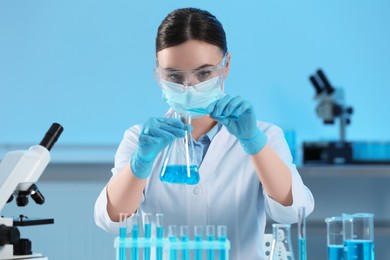 Photo of Scientist working with beaker and test tube in laboratory