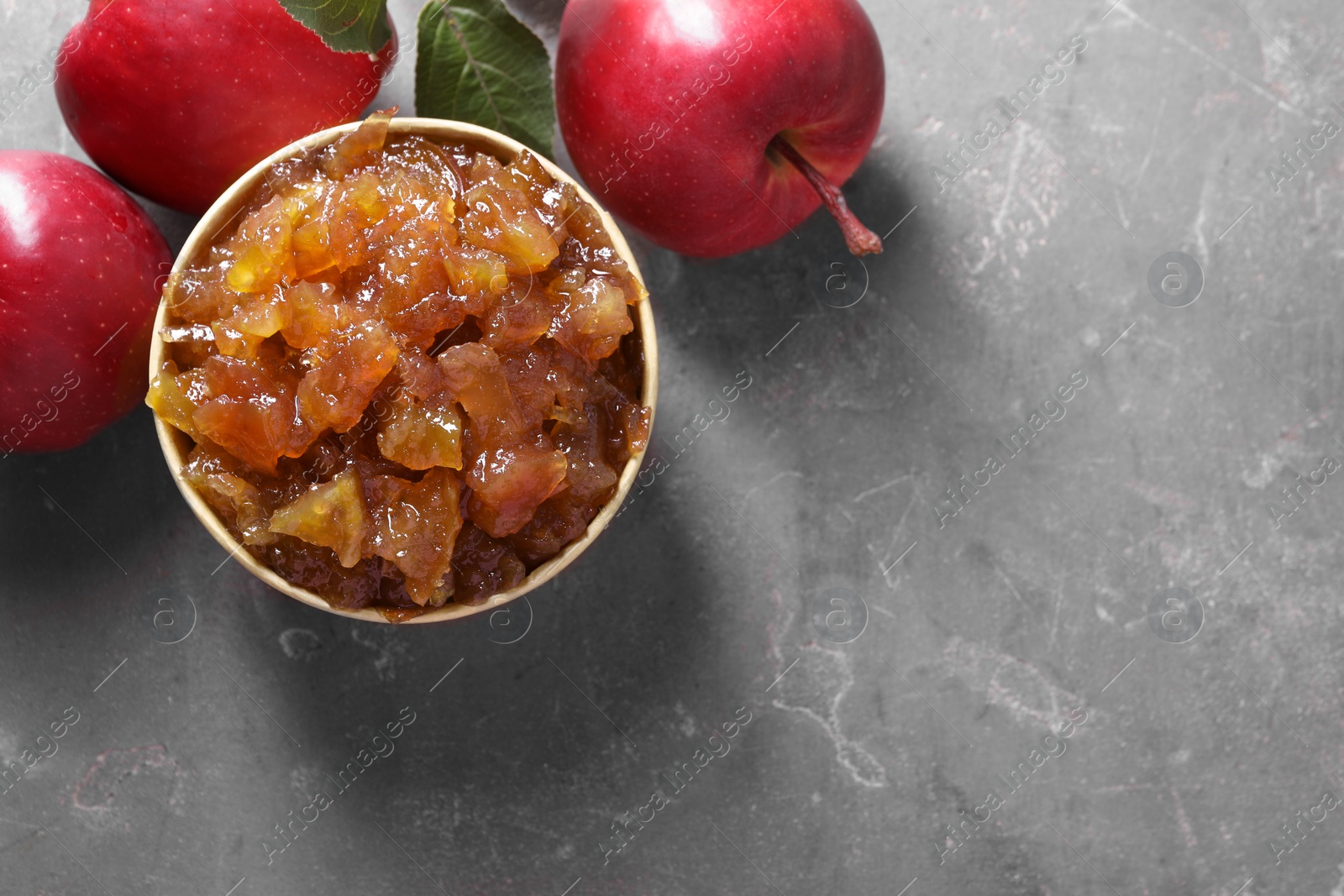 Photo of Delicious apple jam and fresh fruits on grey table, flat lay. Space for text