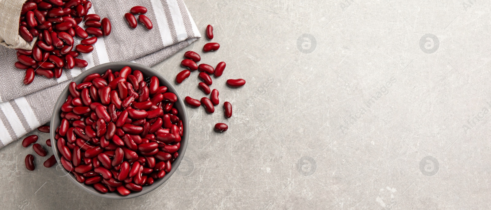 Image of Red kidney beans and space for text on light grey table, flat lay. Banner design