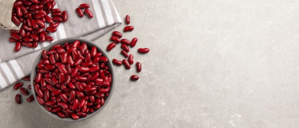 Red kidney beans and space for text on light grey table, flat lay. Banner design