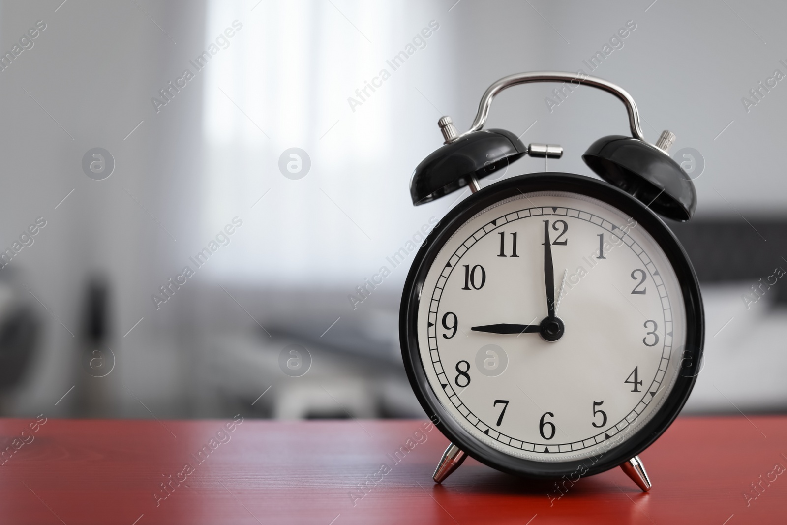 Photo of Alarm clock on table in bedroom. Time of day