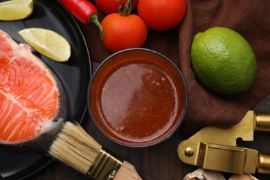 Tasty fish marinade and products on wooden table, flat lay