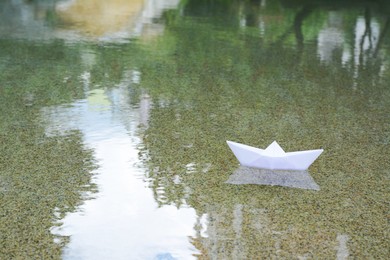 Beautiful white paper boat on water outdoors, space for text