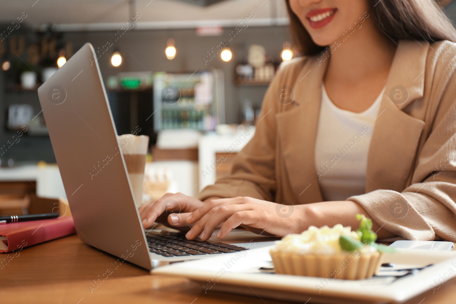 Photo of Blogger working with laptop in cafe, closeup