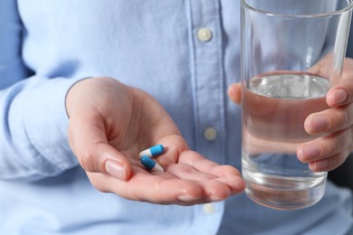 Photo of Woman with glass of water and pill, closeup