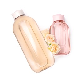 Photo of Bottles of micellar cleansing water and flowers on white background, top view