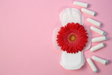 Photo of Flat lay composition with period supplies and flower on color background. Gynecological checkup