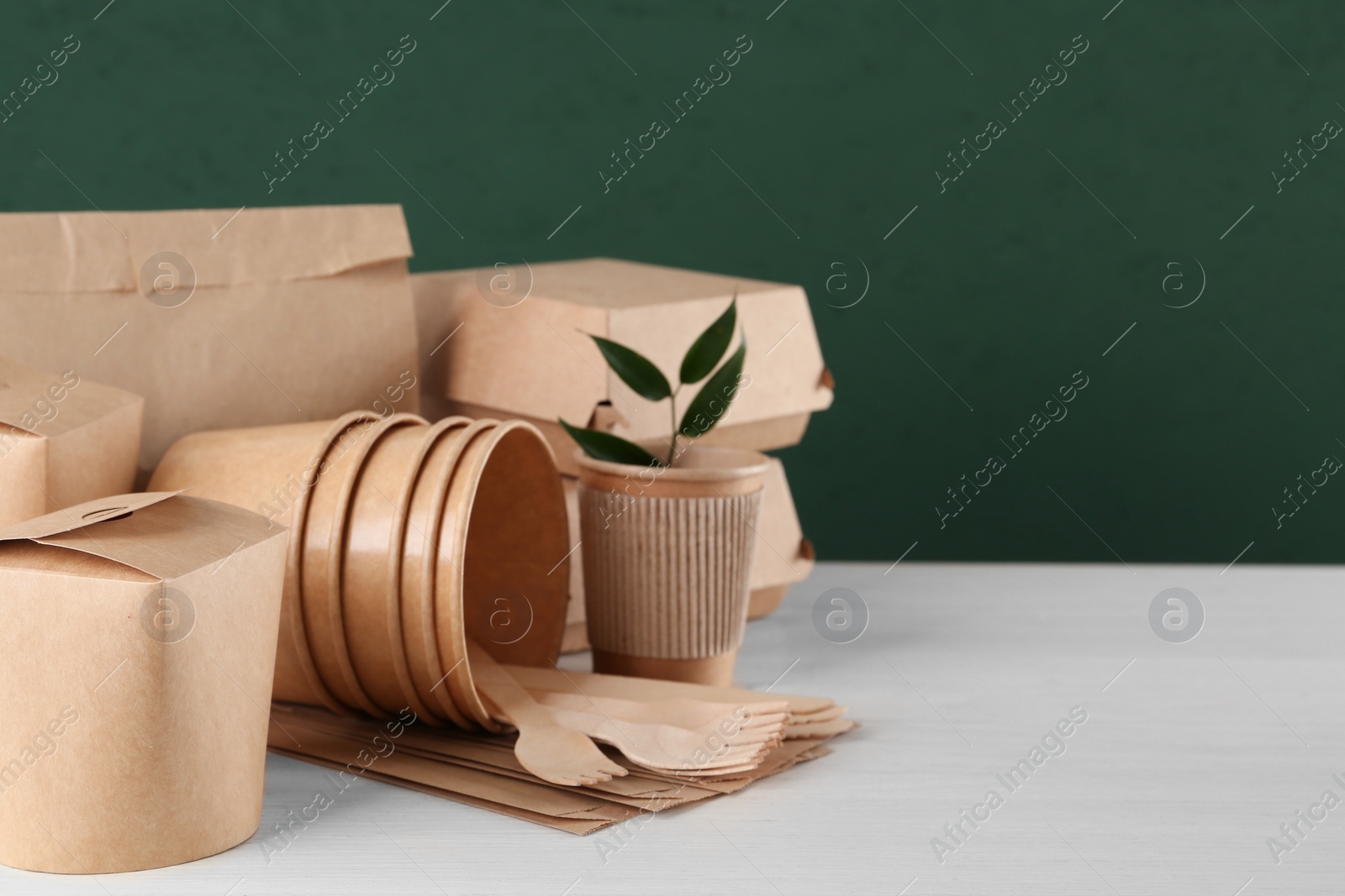 Photo of Disposable eco friendly products on white wooden table