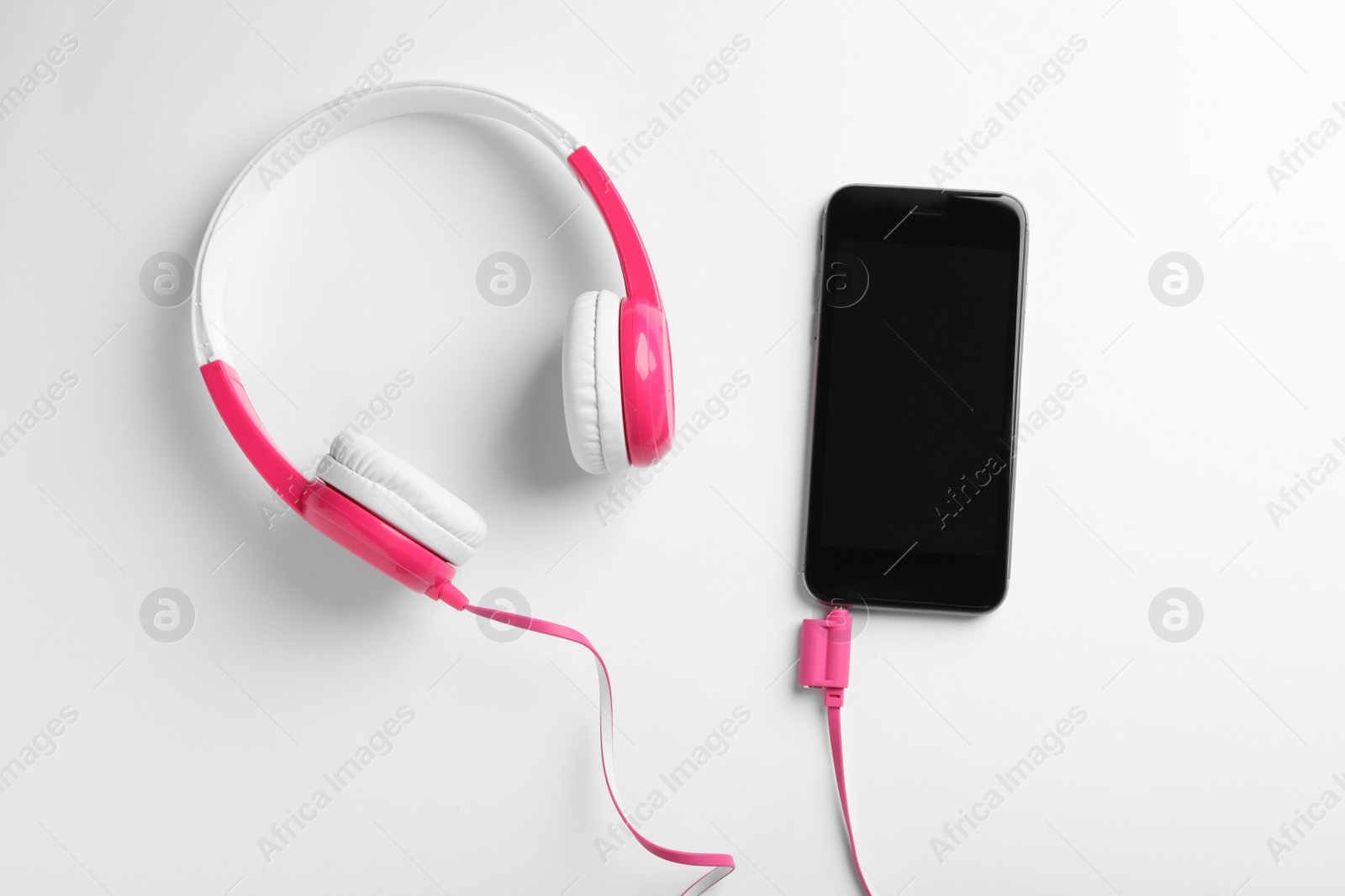 Photo of Stylish headphones and modern phone on white background, top view. Space for text