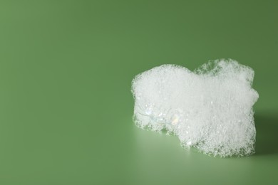 Photo of Drop of fluffy bath foam on olive background. Space for text