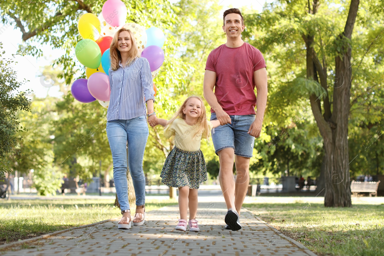 Photo of Happy family with colorful balloons outdoors on sunny day