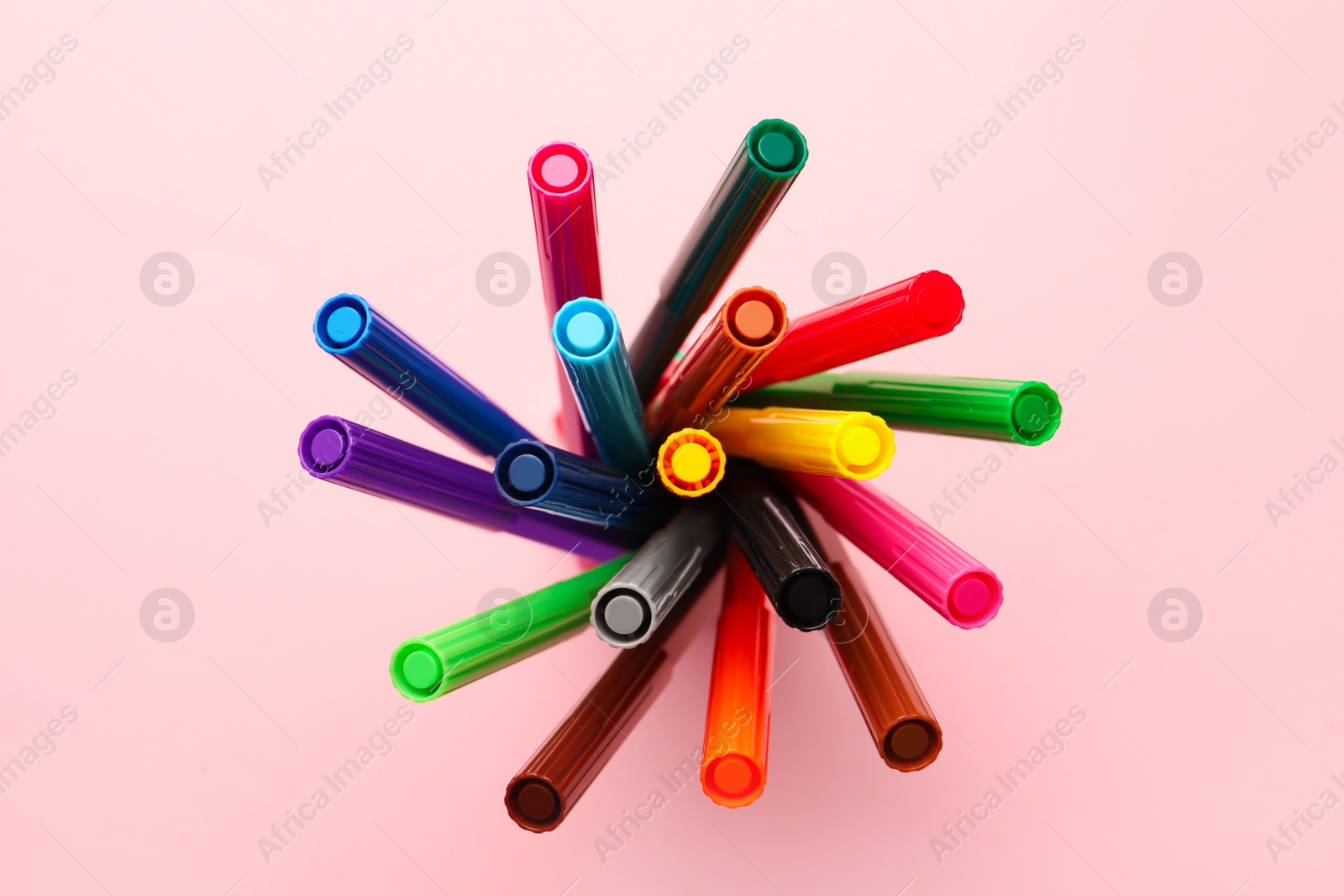 Photo of Many bright markers on pink background, top view