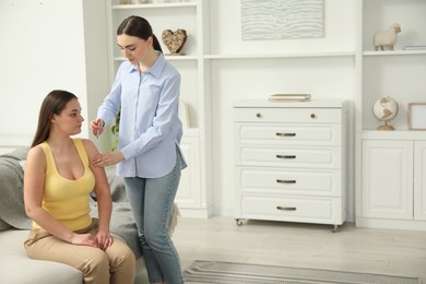 Photo of Woman giving insulin injection to her diabetic friend at home, space for text