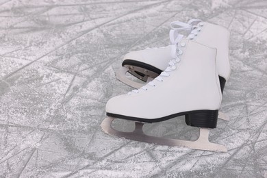 Photo of Pair of figure skates on ice, space for text