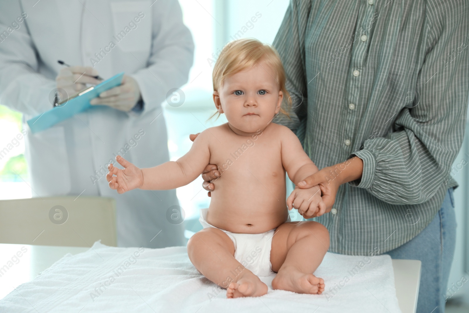 Photo of Mother with her baby visiting pediatrician in hospital. Health growth