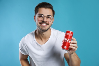 Photo of MYKOLAIV, UKRAINE - NOVEMBER 28, 2018: Young man with Coca-Cola can on color background