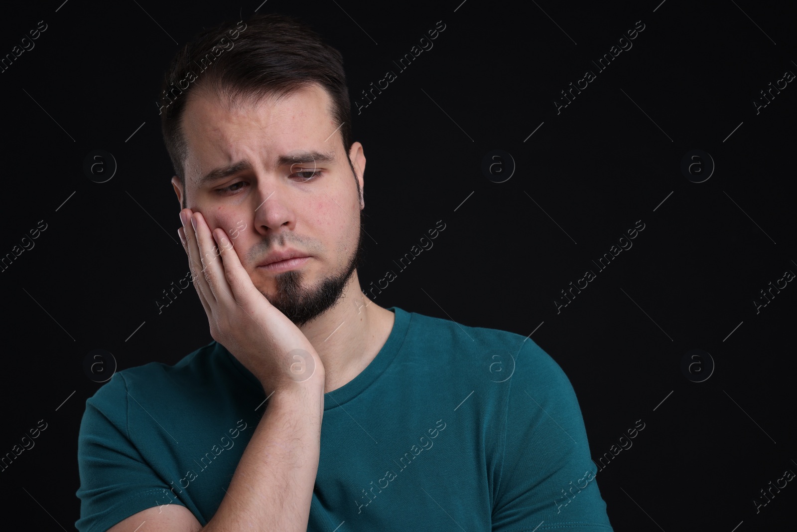 Photo of Portrait of sad man on black background, space for text