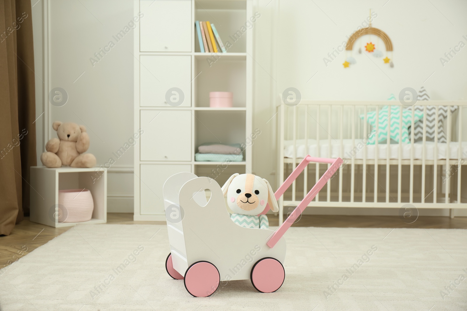 Photo of Toy walker with soft dog in baby room. Interior design