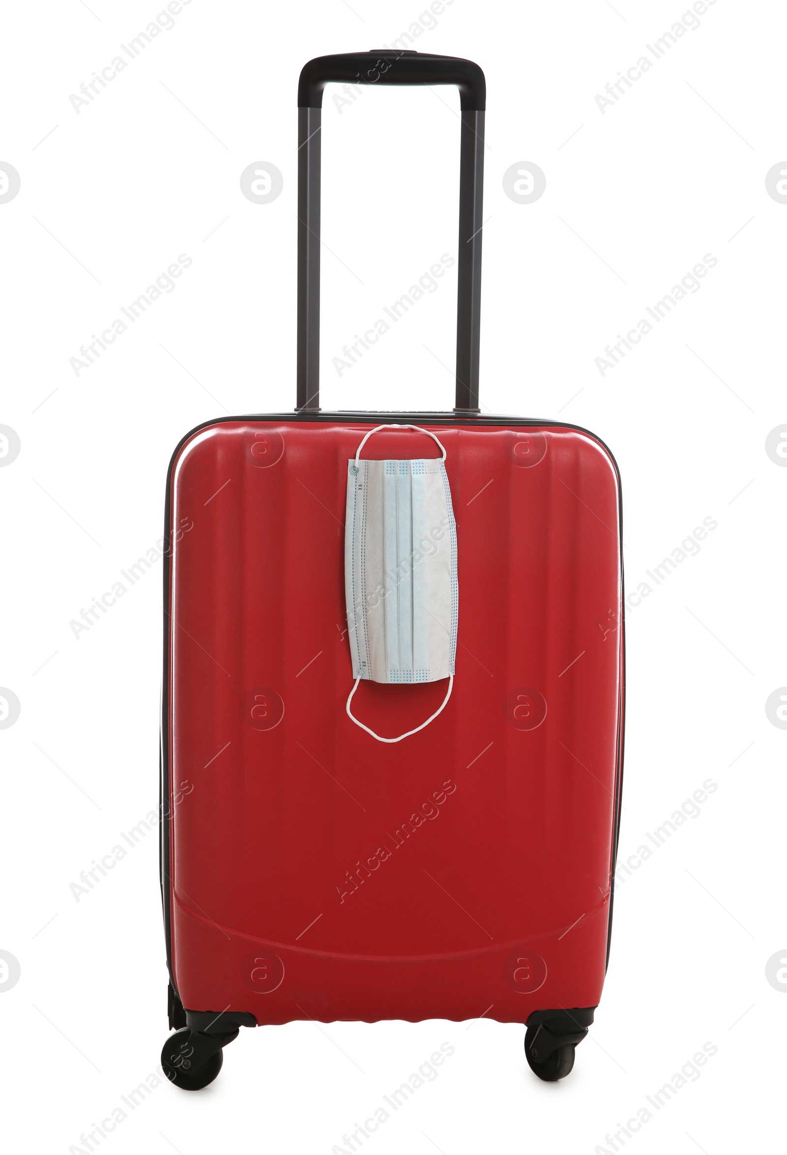 Photo of Stylish red suitcase and protective mask on white background. Travelling during coronavirus pandemic