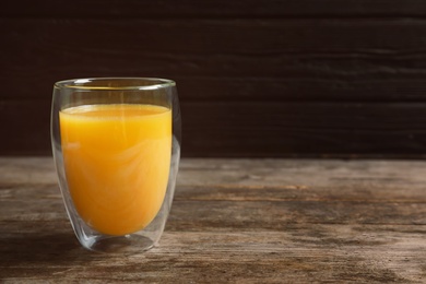 Glass of orange juice on wooden table