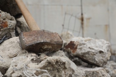 Photo of Sledgehammer on of broken stones outdoors, closeup. Space for text