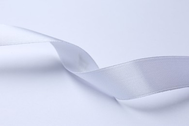 Photo of One beautiful silk ribbon on white background