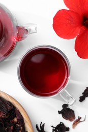 Delicious hibiscus tea and flowers on white background, flat lay