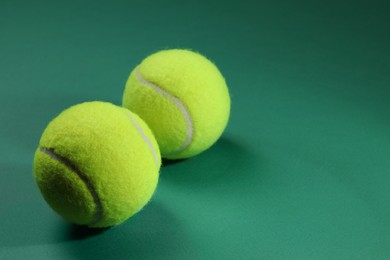 Photo of Two tennis balls on green background, space for text