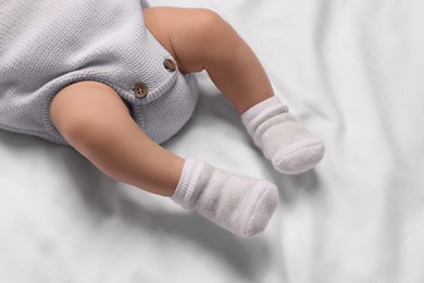 Photo of Newborn baby lying on white blanket, above view