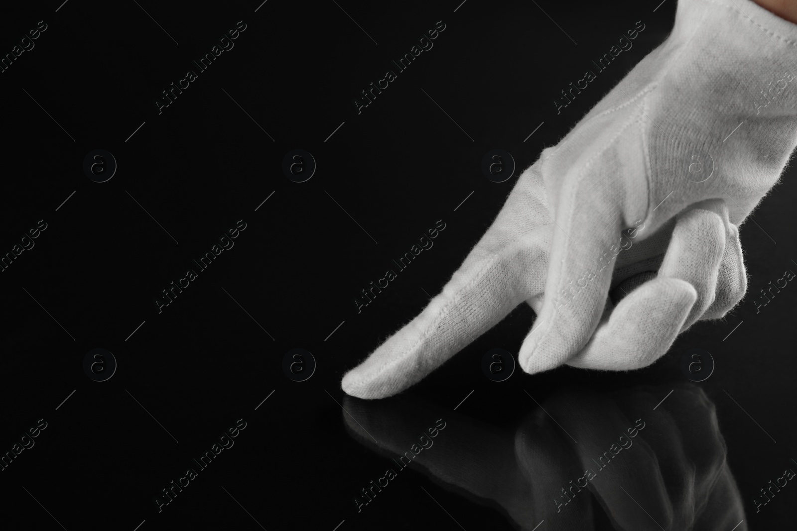 Photo of Woman checking cleanliness of black surface, closeup