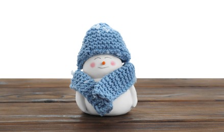 Photo of Cute decorative snowman in blue hat and scarf on wooden table against white background